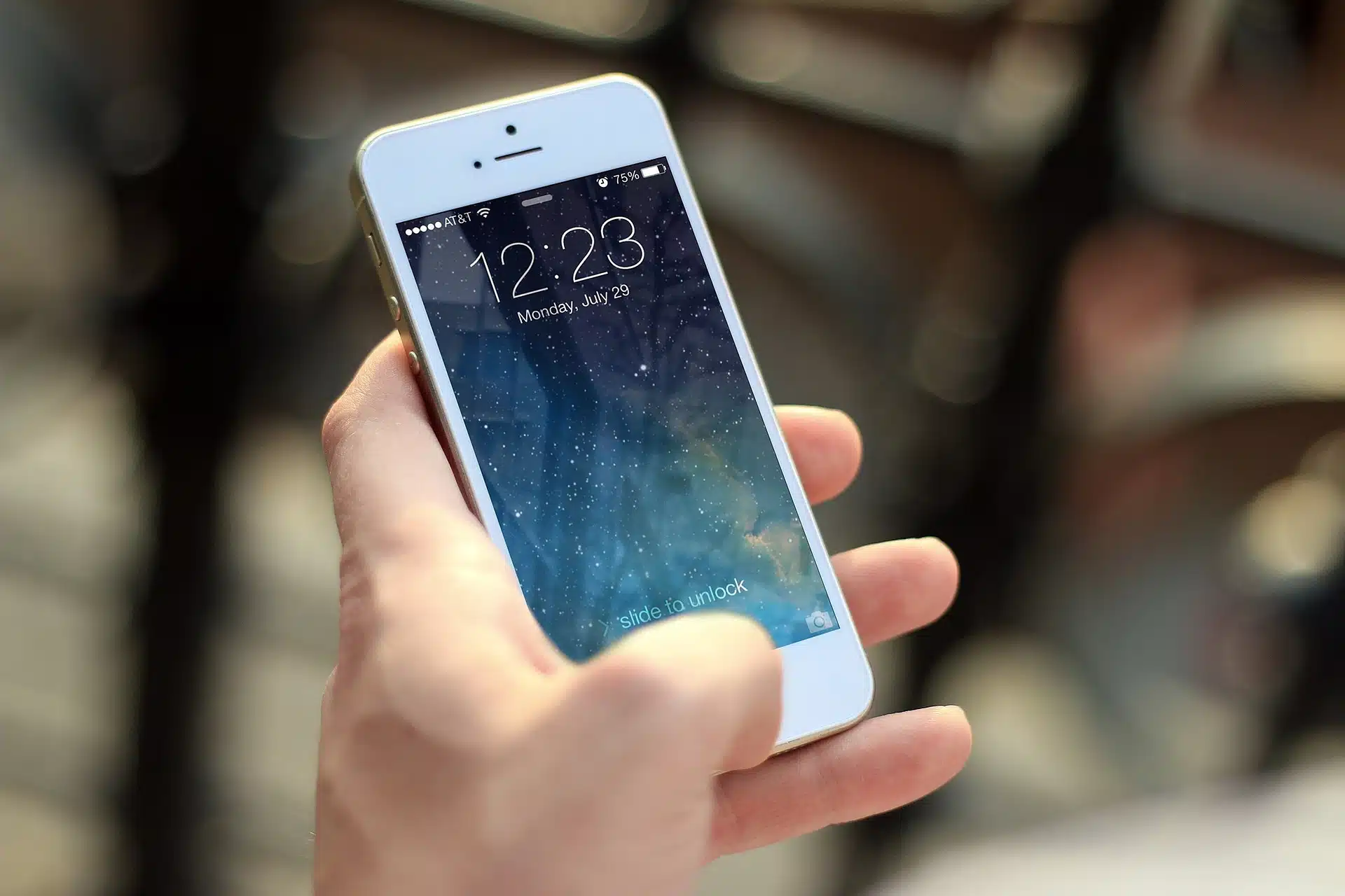 A hand holding a smartphone with a vibrant screen.